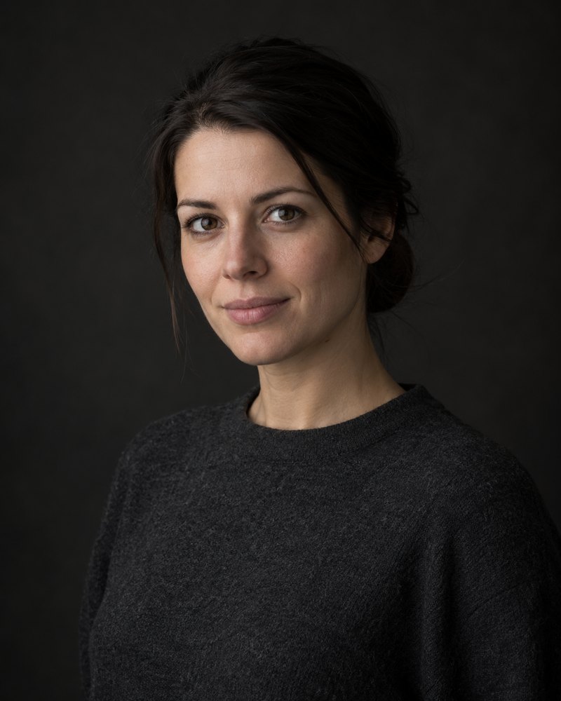 Senta Holm, dunkles Haar im Knoten, schlichtes Wollhemd, dunkles Studio